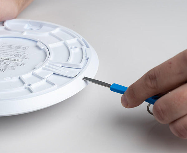 Ubiquiti® Wifi Access Point Unlock & Reset Tool - Hand using tool to reach tight space - Primus Cable